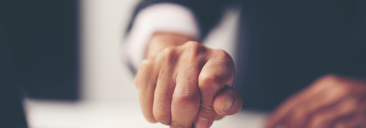Close-up Of A Person's Hand Stamping With Approved Stamp On Document At Desk