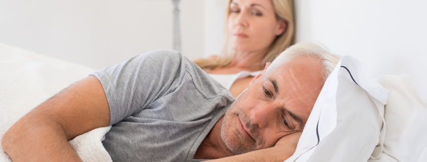 Jealous woman spying her husband mobile phone while he is reading a message.